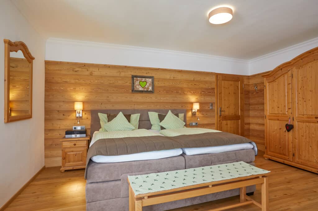 Ferienwohnung Rehbock_Gemütliches Schlafzimmer mit braunem Boxspringbett_Gästehaus Isarwinkel in Krün